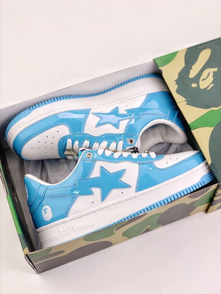 Blue and white sneakers with star design in a box on a light gray background