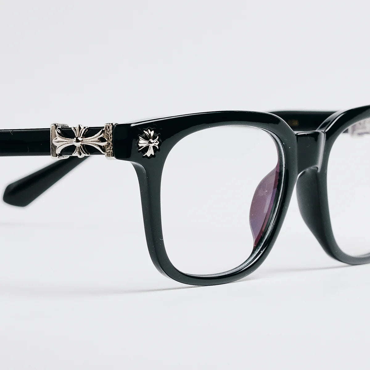 Black eyeglasses with decorative arm on a white background