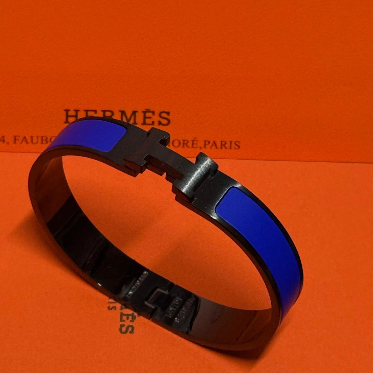 Blue and black bracelet on an orange Hermès background