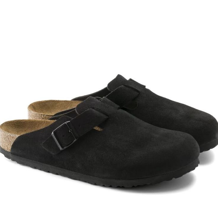 Black suede clogs with a buckle on a white background