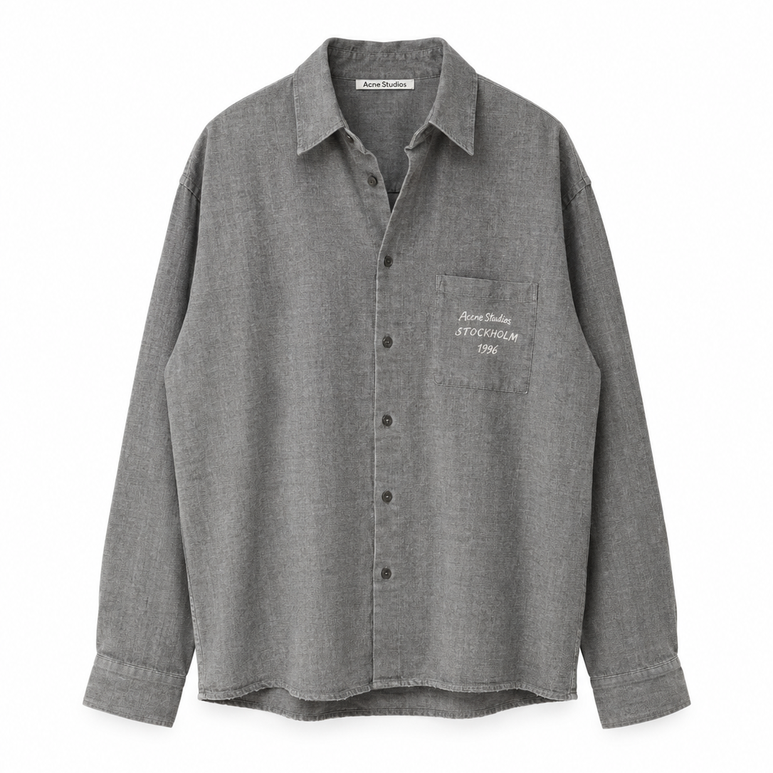 A gray long-sleeve button-up shirt with a pointed collar, buttoned front, and a chest pocket featuring white embroidered text, shown against a plain white background.