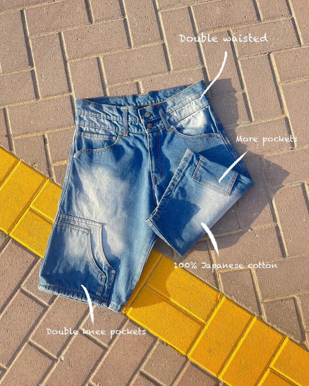 Blue jeans on a tiled pavement with text highlighting features