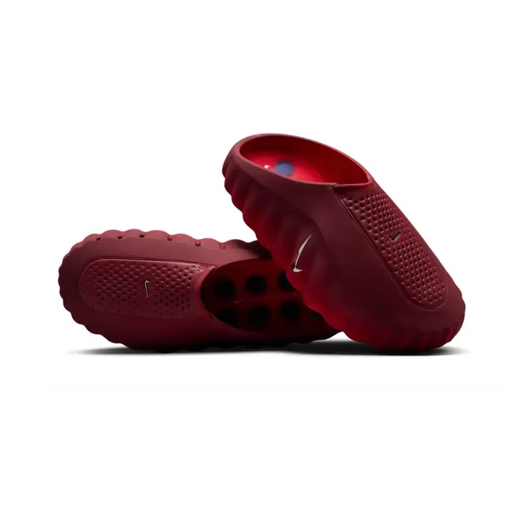 Red rubber shoes with textured sole on a white background